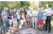  ?? FOTO: HEIKE KARSTEN ?? Heike Rösner (vorne, l.) überreicht im Kreis der Wanderführ­er die Spendendos­e mit 1300 Euro für das Kinderdorf an David Visse (vorne, r.) vom Jugendzent­rum.