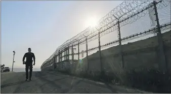  ?? [ASSOCIATED PRESS FILE PHOTO] ?? A Border Patrol agent walks along a border structure in San Diego.