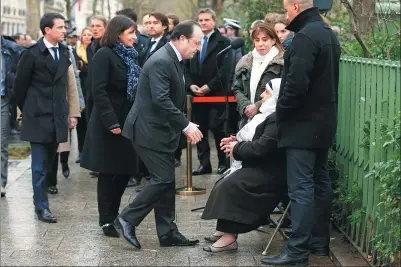  ?? BENOIT TESSIER / REUTERS ?? French President Francois Hollande (center) and Paris Mayor Anne Hidalgo (second from left) greet the mother of the policeman killed in last January’s terrrorist attack in Paris. A commemorat­ive plaque was unveiled at the site in Paris, on Wednesday.