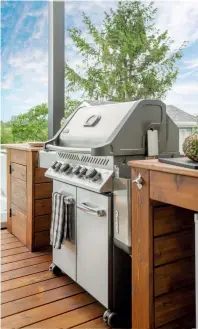  ?? ?? À l'autre extrémité du patio, un coin barbecue a été conçu avec le même bois que la structure. Il offre des surfaces de travail, du rangement pratique et même un ouvre-bouteille intégré !