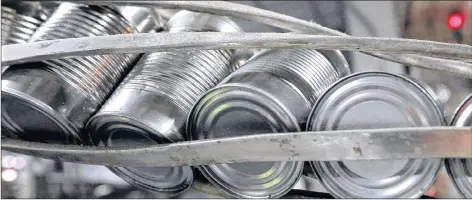  ?? CP PHOTO ?? Canned processed pumpkins move along a conveyor belt in the case and label area of a cannery in Morton, Ill. Canned food companies say they are eyeing increasing prices to combat the affects of aluminum tariffs.