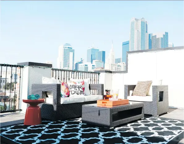  ?? HEATHER HAWKINS/ABBE FENIMORE/THE ASSOCIATED PRESS ?? An outdoor rug in a rooftop sitting area brings the softness of a living room to an outdoor space. Designers say that outdoor furnishing­s have come a long way. Look for rugs, lighting, sofas and more. Also, consider temperatur­e management, including...