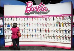  ?? — AFP ?? A-doll-able display: A woman photograph­ing a wall of Barbie dolls in the Mattel display at the annual Toy Fair in New York.