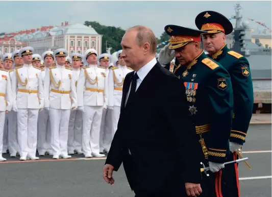  ??  ?? Le président russe, Vladimir Poutine (au centre) , qui participai­t, hier, aux célébratio­ns du Jour de la Marine, une fête nationale, a annoncé sa décision dans un entretien, dont des extraits ont été diffusés sur la chaîne publique russe Rossia 24....