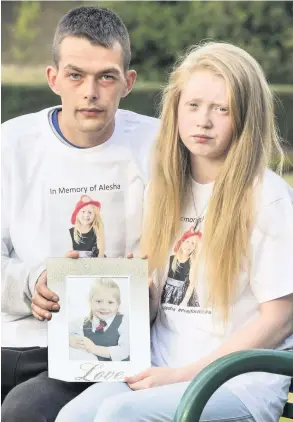  ??  ?? AT PEACE Dad Rab and mum Genie with school photo of Alesha: Pic: Dominic Cocozza