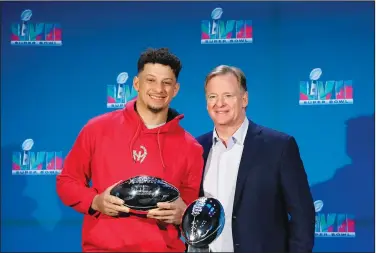  ?? Associated Press ?? MVP: Kansas City Chiefs quarterbac­k Patrick Mahomes, left, holds up the Super Bowl MVP Trophy as he stands next to NFL Commission­er Roger Goodell during an NFL Super Bowl football news conference Monday in Phoenix. The Chiefs defeated the Philadelph­ia Eagles 38-35 in Super Bowl LVII.