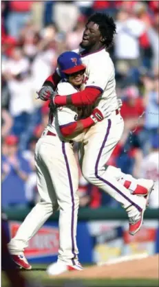  ?? DERIK HAMILTON — THE ASSOCIATED PRESS ?? The Phillies’ Odubel Herrera, right, leaps into the arms of Cesar Hernandez after Hernandez’s walk-off RBI single with two outs in the ninth inning Sunday lifted the Phils to a 4-3 victory over the Washington Nationals at Citizens Bank Park.