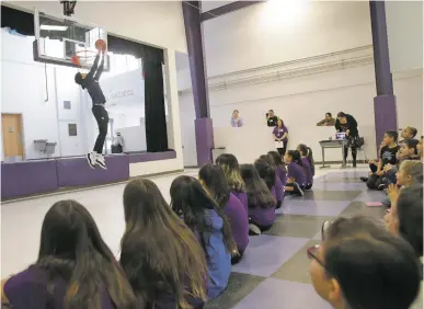  ??  ?? ABOVE: Santa Fe High basketball player Fedonta ‘JB’ White dunks for Kearny Elementary students in grades 3-6 on Wednesday.