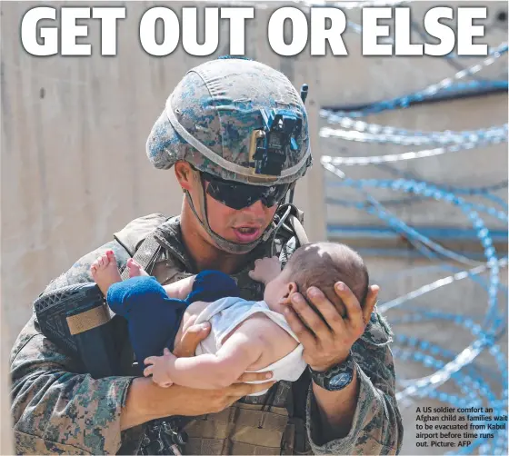  ?? Picture: AFP ?? A US soldier comfort an Afghan child as families wait to be evacuated from Kabul airport before time runs out.