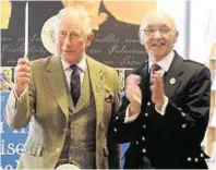  ??  ?? Prince Charles cuts a cake with John Macleod