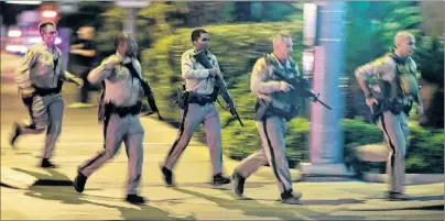  ?? AP PHOTO ?? Police run to cover at the scene of a shooting near the Mandalay Bay resort and casino on the Las Vegas Strip in Las Vegas on Oct. 1, 2017, following the worst mass shooting in modern U.S. history.