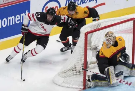  ?? PAUL CHIASSON/THE CANADIAN PRESS ?? Team Canada’s Connor McDavid shakes off German defenceman Fabio Wagner behind goalie Kevin Reich in Saturday night’s game in Montreal.