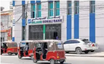  ?? REUTERS ?? Rickshaw taxis drive past the Salaam Somali Bank in Wadajir district of Mogadishu, Somalia.