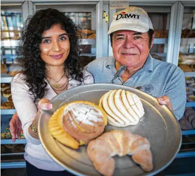  ?? Mark Mulligan / Houston Chronicle ?? Jackie Garza, 18, and her father, Trinidad Garza, display some of the specialtie­s at La Casa Bakery and Restaurant. Thousands of Twitter users who saw her message helped convince the elder Garza to keep the business open.