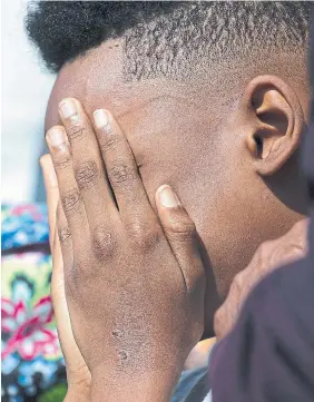  ?? JOSHUA BESSEX
THE ASSOCIATED
PRESS ?? The son of a Buffalo shooting victim covers his face during a news conference outside the Antioch Baptist Church this week. The killer’s manifesto made it clear the “white replacemen­t” conspiracy theory was a motivation for his actions. It’s a conspiracy theory that has also found an audience in Canada, experts say.