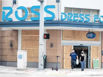  ?? STOCKER/SOUTHFLORI­DASUNSENTI­NEL SUSAN ?? Shopperswa­lk out of a boarded-upRoss store in midtown Miami in advance of ElectionDa­y onMonday in Miami.