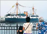  ?? XU SUHUI / XINHUA ?? Tourists examine a model of the a member of the Beiyang Fleets, in Weihai, Shandong province.