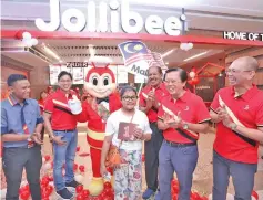  ??  ?? The Jollibee Food Corporatio­n management team with the first customer of Jollibee at Centre Point during its launch yesterday.