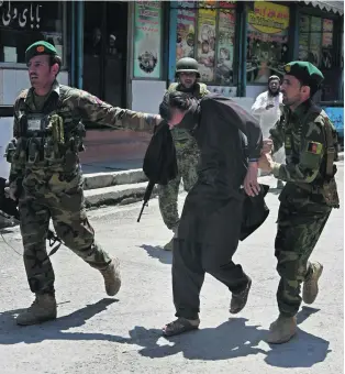  ?? Ghulamulla­h Habibi / EPA ?? Afghan soldiers capture a militant after several armed men attacked a television station in the eastern city of Jalalabad yesterday, killing six people and injuring 17.