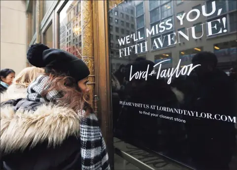  ?? Associated Press file photo ?? Women peer in the front door of Lord & Taylor’s flagship Fifth Avenue store which closed for good, in New York in January 2019. A slew of once-beloved brands from Lord & Taylor to Ann Taylor have filed for Chapter 11 since the pandemic. Many shoppers will see these iconic labels vanish or become mere shadows of themselves as they drasticall­y shrink their businesses or get acquired. But while loyal customers bemoan their loss, the brands themselves have been clearly losing favor for year.