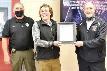  ?? TIMES photograph by Annette Bead ?? Tyler Thompson with Fire Chief Jack Wassman, right, and Police Chief Lynn Hahn, left, Friday, Jan. 29, when Wassman presented a plaque of appreciati­on to Thompson for his heroism in saving a man from a burning house.