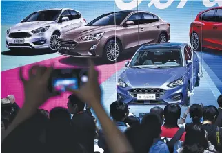  ?? AFP ?? VISITORS LOOK at a display for the new Ford Focus at the Beijing auto show in Beijing on April 25. Industry behemoths like Volkswagen, Daimler, Toyota, Nissan, Ford and others will display more than 1,000 models and dozens of concept cars at the...