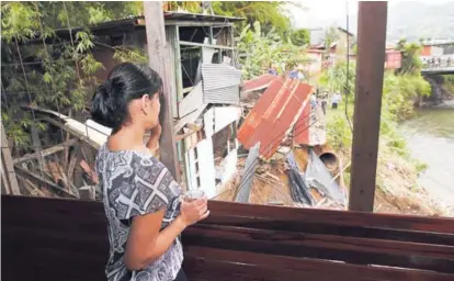  ?? JOHN DURÁN ?? María Gutiérrez, una de las afectadas, observaba este jueves los trabajos para desmantela­r casas que, como la suya, están a orillas del río Tiribí incumplien­do las zonas de protección.