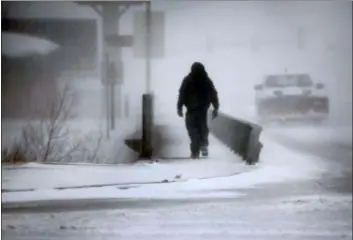  ?? JACOB BYK — THE WYOMING TRIBUNE EAGLE VIA AP ?? A man crosses Crow Creek during a blizzard on Wednesday in Cheyenne, Wyo. Heavy snow hit Cheyenne about mid-morning Wednesday and was spreading into Colorado and Nebraska.