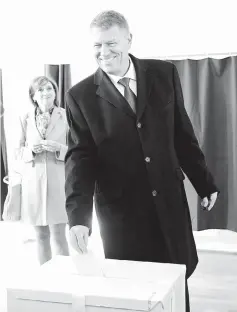  ??  ?? Iohannis casts his vote at a polling station in Sibiu. — AFP photo