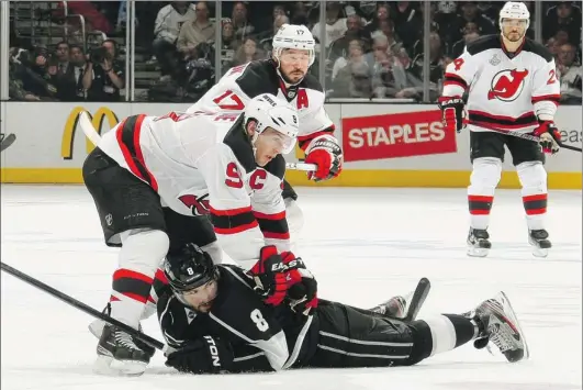  ?? DAVE SANDFORD/ NHLI VIA GETTY IMAGES ?? Captain Zach Parise of the New Jersey Devils pushes defenceman Drew Doughty of the Los Angeles Kings to the ice, while teammates Ilya Kovalchuk and Bryce Salvador ( right) head up ice. The Devils scored three goals in the third period to net a 3- 1 win...