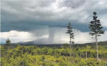 ??  ?? A storm passes over Mount Katahdin in this view from land that is now the Katahdin Woods and Waters National Monument in northern Maine. Motorists on Interstate 95 in Maine won’t see signs directing them to the new national monument because Gov. Paul...