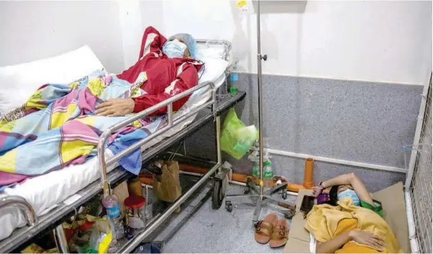  ?? Reuters ?? ↑
A coronaviru­s patient rests while his daughter sleeps on the floor of the COVID-19 emergency room at a hospital in Metro Manila on Monday.