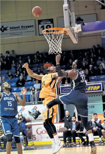  ?? SUPPLIED PHOTO ?? Niagara’s Sam Muldrow, left, and Niagara’s Kirk Williams Jr., left, battle an Island Storm player for possession in National Basketball League of Canada action Thursday night in Charlottet­own.