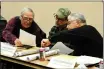  ?? GEOFFREY PLANT/Taos News ?? From left, John MacArthur, Darryl Maestas and Carlos Arguello pore over documents during the first meeting of the Talpa Foothills Working Group, which the Carson National Forest formed in order to get community input on how to best plan recreation­al trails in the forest adjacent to Taos and Talpa.