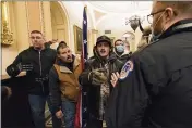  ?? MANUEL BALCE CENETA — THE ASSOCIATED PRESS ?? On Jan. 6, Kevin Seefried, second from left, holds a Confederat­e battle flag as he and other insurrecti­onists loyal to President Donald Trump are confronted by U.S. Capitol Police officers outside the Senate Chamber in Washington.