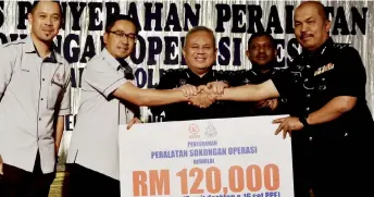  ?? — Bernama photo ?? Mohd Yaakob (second le ) shakes hands with Sabah CID chief SAC Sapii Ahmad during the symbolic handing over of support tools, witnessed by Abdul Jalil (centre) and others.
