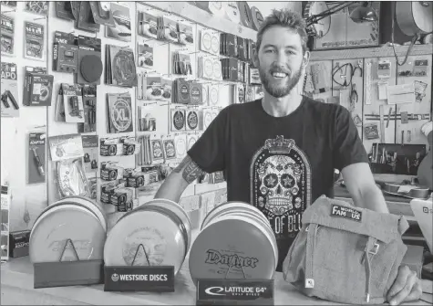  ?? CAROLE MORRIS-UNDERHILL ?? Tony Wood, co-owner of the Spoke &amp; Note on Water Street in Windsor, displays the typical equipment required to play disc golf. The store sells and rents the gear, with a full-day rental costing $5.