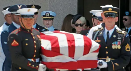  ??  ?? Respect: Uniformed members of the US military carry the flag-draped coffin in Arizona yesterday