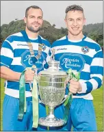  ??  ?? Man-of-the-match Evan Menzies (left) and Newtonmore captain Andy Mackintosh with the Camanachd Cup.