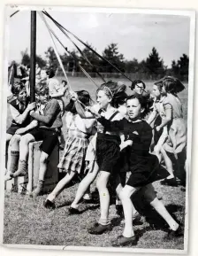  ??  ?? Children dance around a maypole at Marchant’s Hill Camp School in Hindhead, Surrey