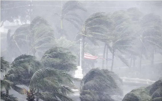  ?? THE ASSOCIATED PRESS ?? An American flag is ripped apart in the 177 km/h winds as Hurricane Irma blows through Naples, Fla., on Sunday after causing massive destructio­n in the Caribbean.
