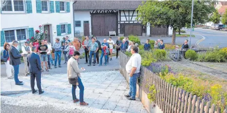  ?? FOTO: CHRISTOPH KLAWITTER ?? Die Teilnehmer des Rundgangs schauen sich den Vorplatz (links) und das Gartenstüc­k (rechts) neben der Alten Kirche an.