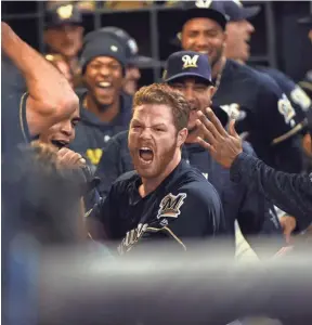  ?? USA TODAY SPORTS ?? Milwaukee Brewers relief pitcher Brandon Woodruff celebrates in the dugout after hitting a homer against the Los Angeles Dodgers in Game 1.