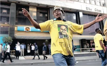  ?? PICTURE: NOKUTHULA MBATHA ?? An #OccupyLuth­uliHouse protester wearing an ANC T-shirt outside the party’s head office in Johannesbu­rg yesterday, where they demanded that President Jacob Zuma and the party’s National Executive Committee step down.