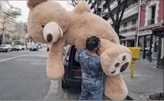 ?? Francois Mori / Associated Press ?? Bookshop owner Philippe Labourel, who wants to be named “Le papa des nounours,” “Teddy Bear father,” carries a giant teddy bear to a bar in Paris on March 3.