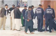  ?? — Reuters photo — Reuters photo ?? Bomb disposal squad personnel are seen after a suicide bomber attacked a crowded Sufi shrine in Sehwan Sharif in this still image taken from video. Men comfort each other as they attend the funeral of a relative who was killed in a suicide blast at the...