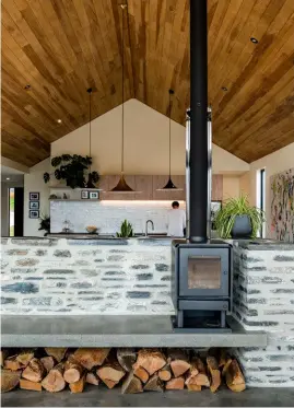  ??  ?? KITCHEN The pitched ceilings are lined with tōtara, which creates a pleasing contrast with the tough black granite benchtop and polished concrete floors.