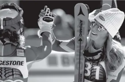  ??  ?? EagleVail’s Mikaela Shiffrin, right, and Slovenia’s Ilka Stuhec exchange high-fives Sunday after the alpine combined event in Crans Montana, Switzerlan­d. Shiffrin was the winner and Stuhec placed third. Alessandro della Valle, The Associated Press