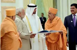  ?? — PTI ?? Temple committee members present the temple literature to Prime Minister Narendra Modi and the Crown Prince of Abu Dhabi, Deputy Supreme Commander of UAE Armed Forces Gen. Sheikh Mohammed Bin Zayed Al Nahyan, at the Presidenti­al Palace in Abu Dhabi on Saturday.