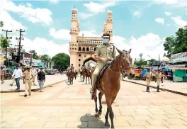 ?? — DC ?? Hyderabad police commission­er Anjani Kumar leads a horse-mounted patrol of the city police during the lockdown near the Charminar on Saturday.